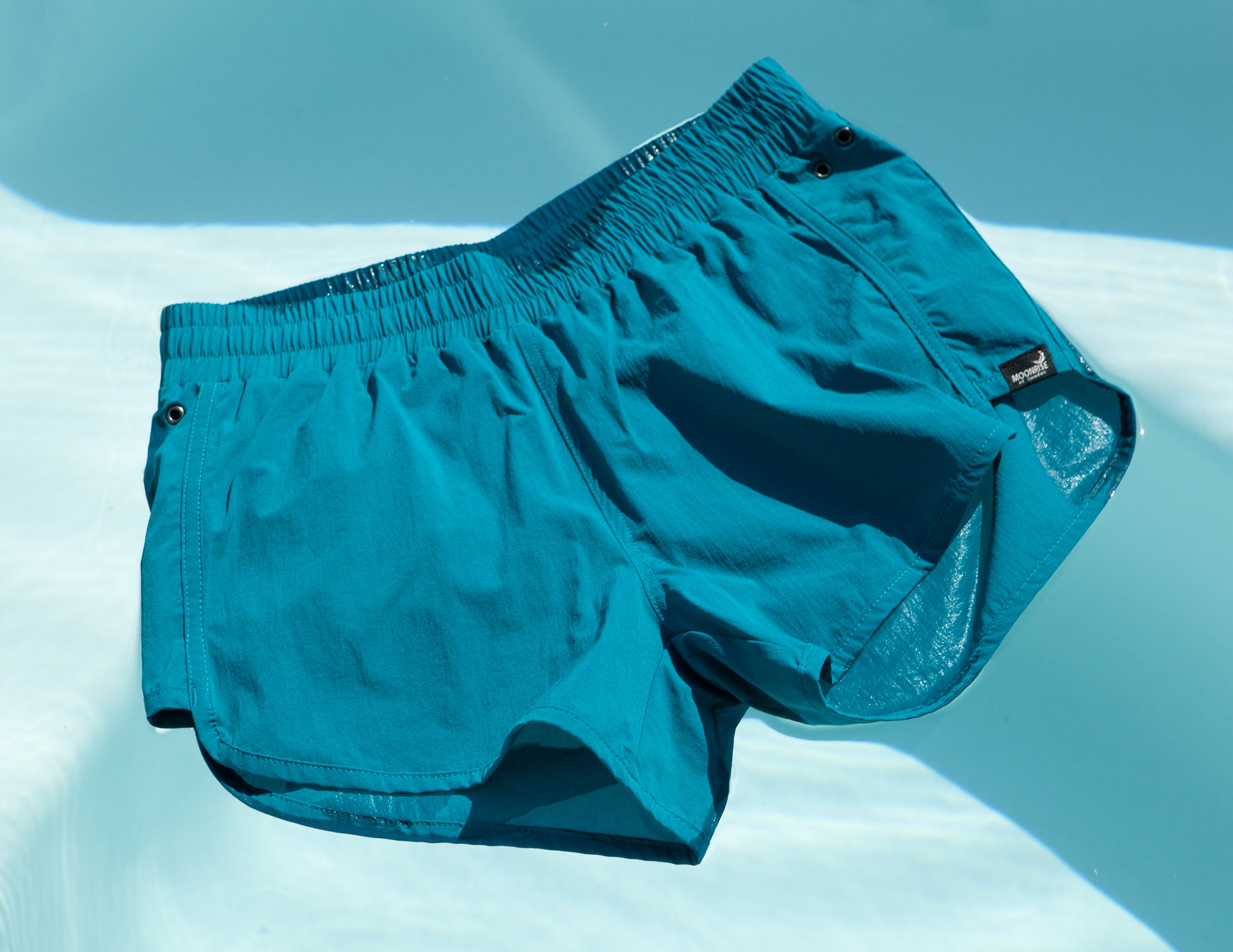 Shortsini Shorts Biscay Bay från Moonrise of Sweden, som flyter i en pool frå